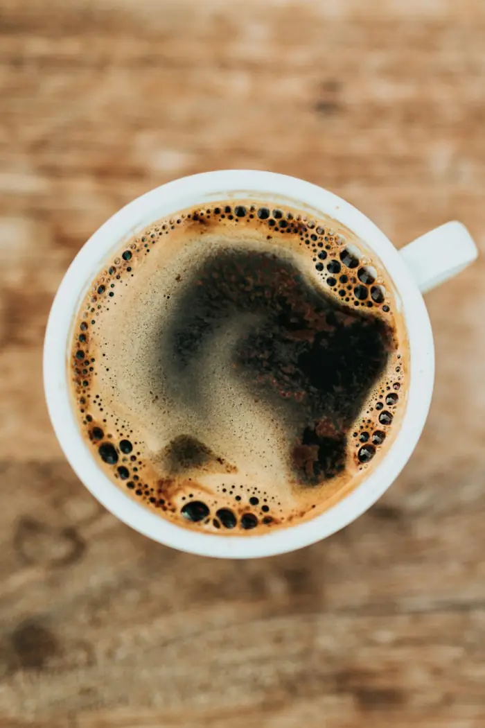 A cup of black coffee on a warm wooden table